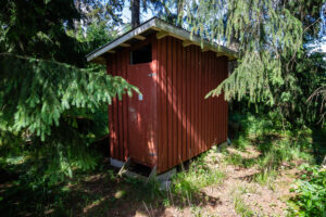 Huussi sijaitsee kämpän takana metsän reunassa